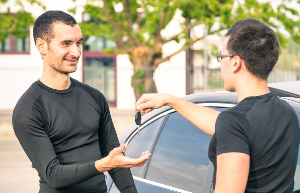 Man giving car keys to the new owner.